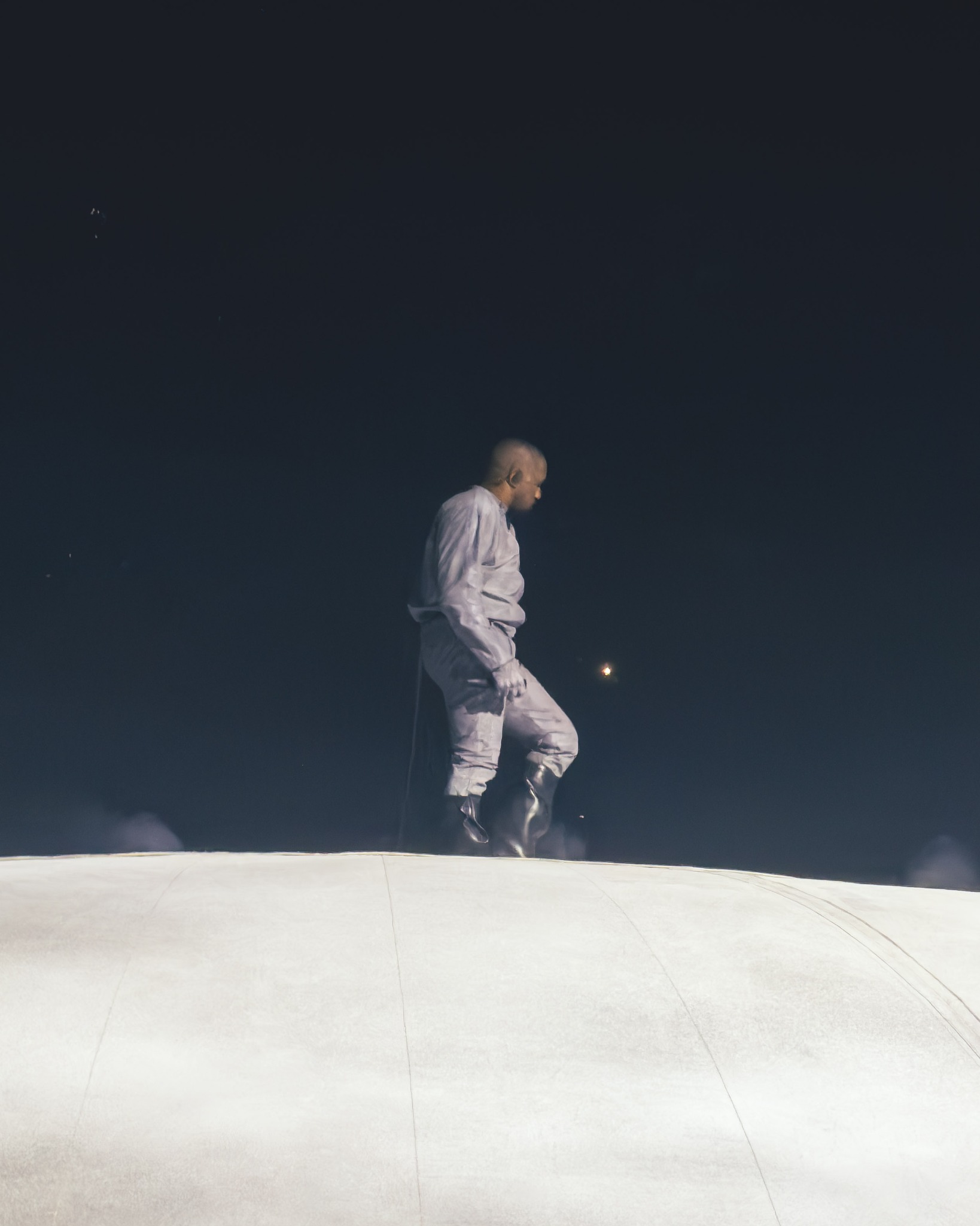 A performer dressed in white standing on the dome