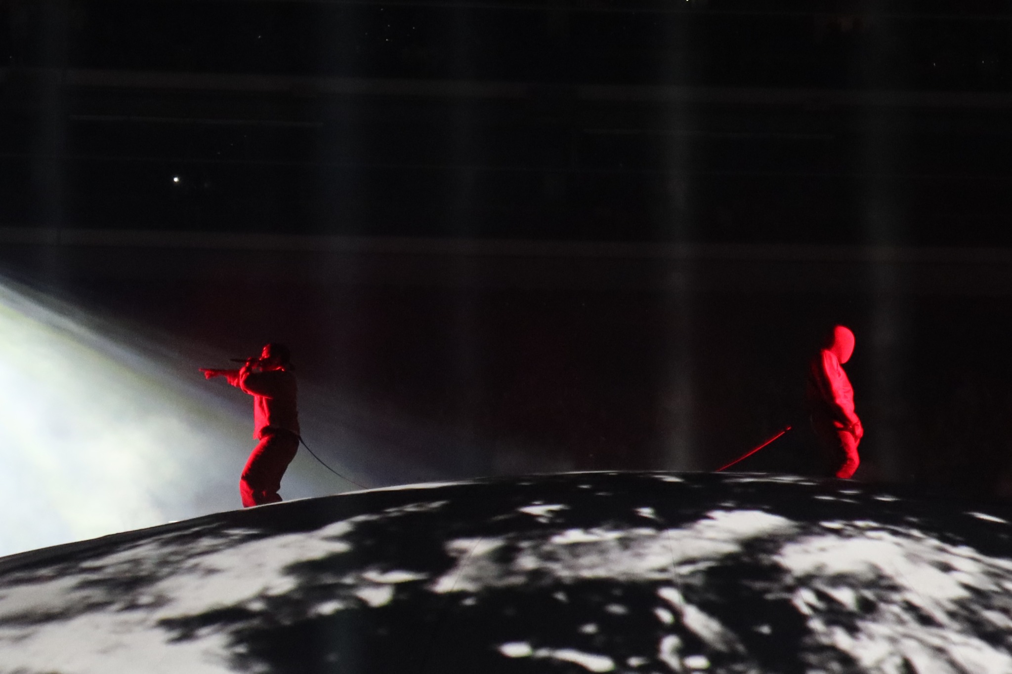 Two performers silhouetted across the dome
