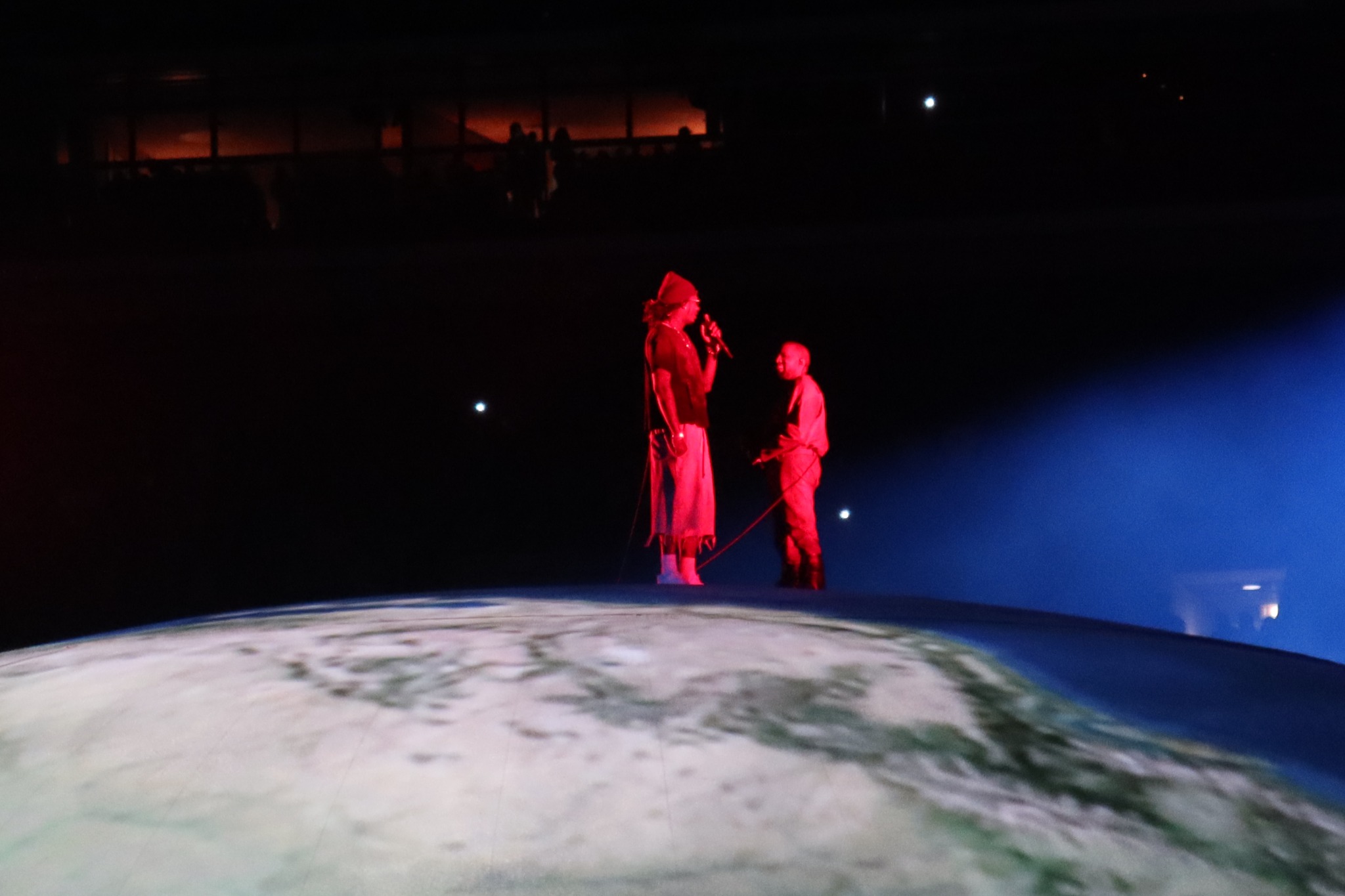 Two artists performing under red and blue light