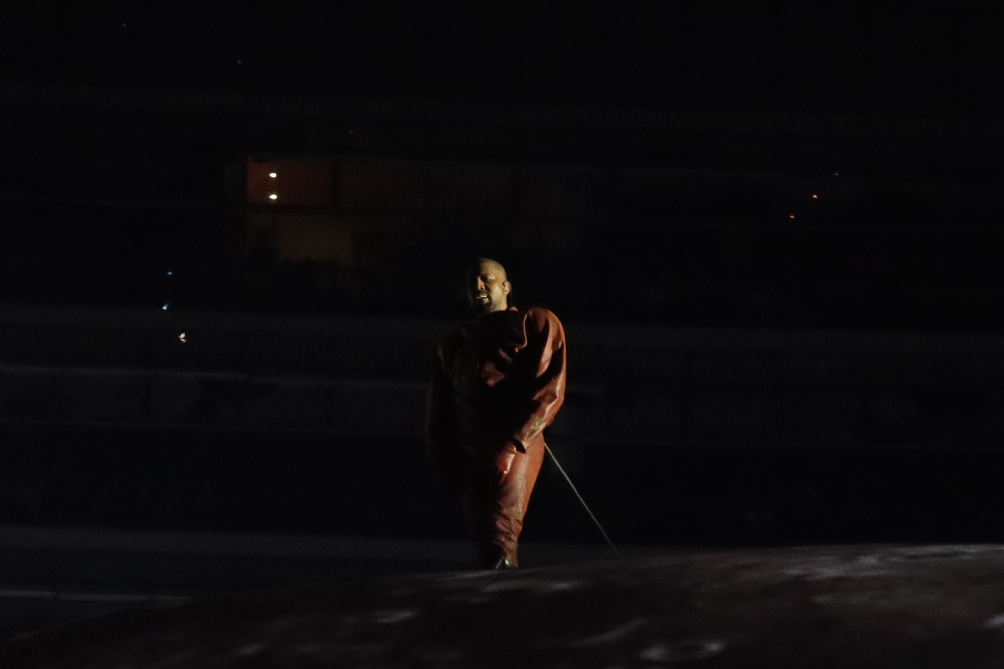 A performer lit against the dark stadium