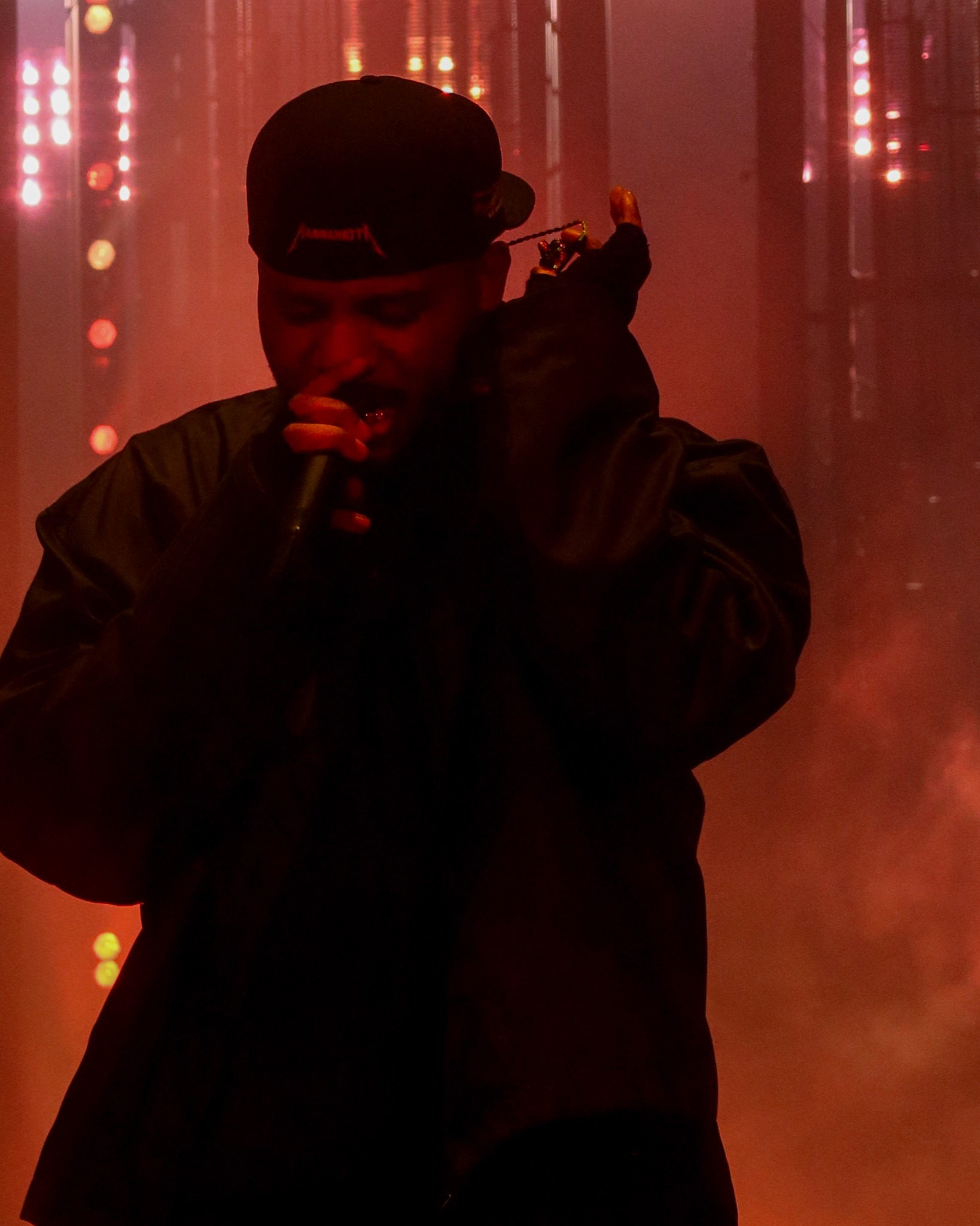 Bryson Tiller performing against red stage lights