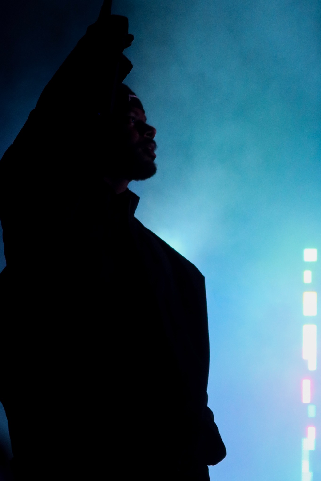 Bryson Tiller silhouetted against blue light