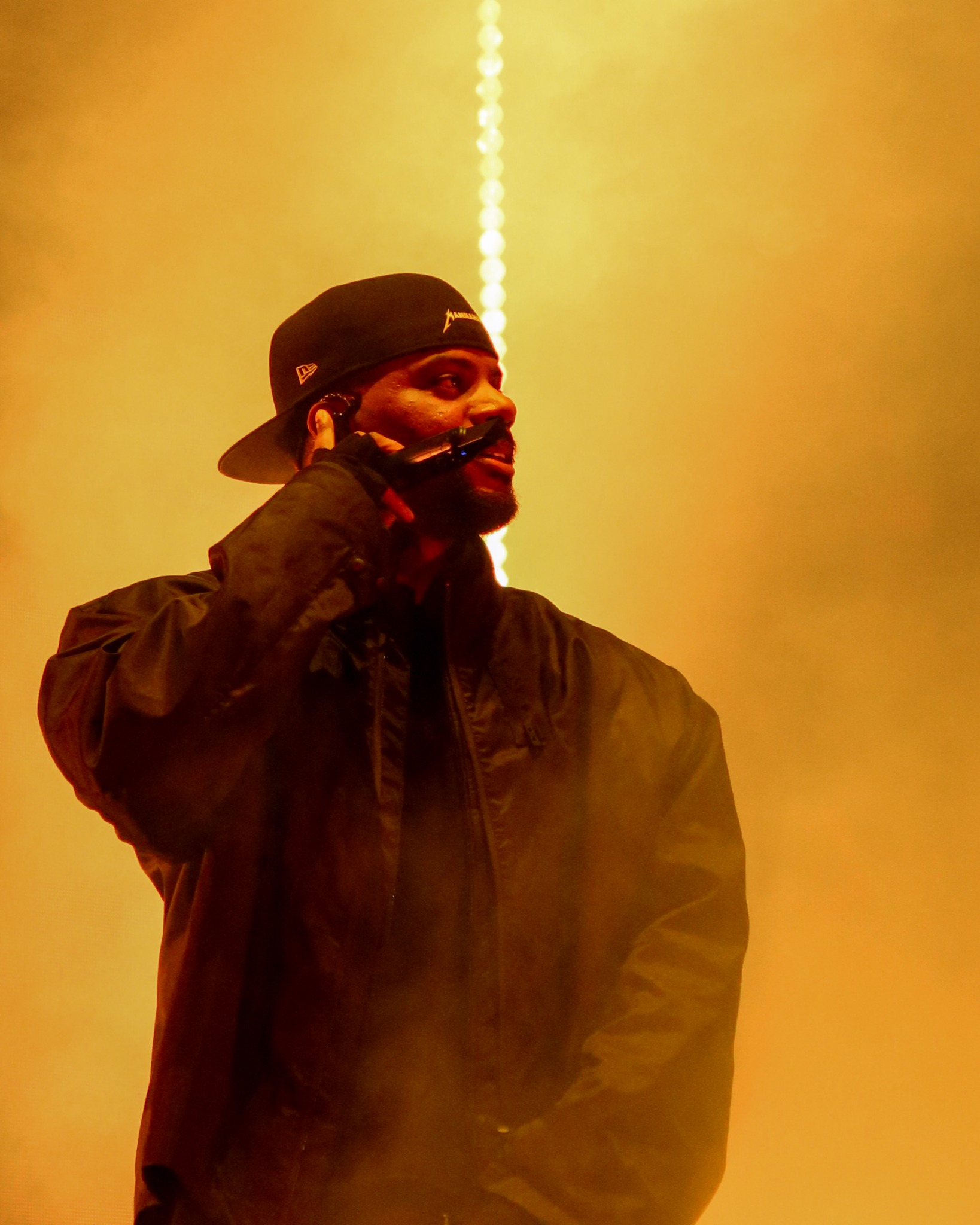 Bryson Tiller singing through amber haze