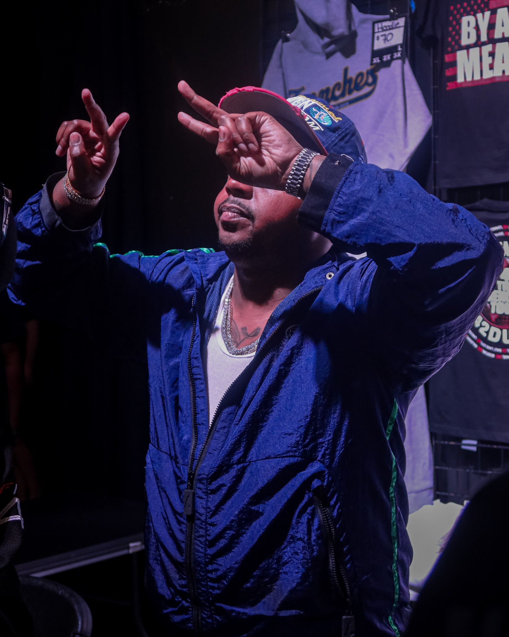 42 Dugg gesturing toward the crowd in a blue jacket